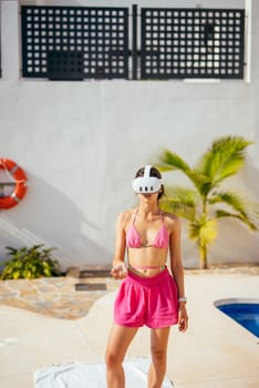 A chic and stylish woman wearing trendy swimwear while using a VR headset and relaxing by the poolside
