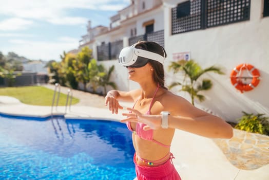 A woman wearing VR goggles fully engages with an exciting immersive virtual experience by a bright, sunny poolside