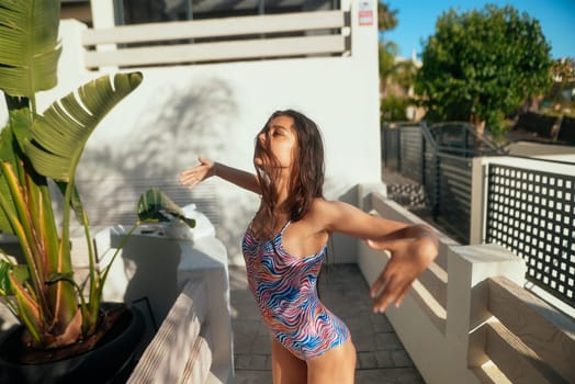 A girl enjoys a sunny day by the sparkling pool, wearing bright swimwear and exuding vibrant summer energy