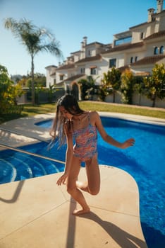 A vibrant and lively scene depicts a joyful girl enjoying her delightful summer by the poolside in bright swimwear