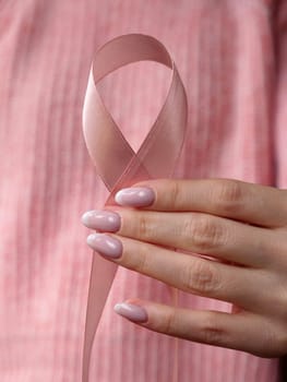 Pink October Breast Cancer Awareness month, woman hand with pink Ribbon in hospital for support people life and illness. Vertical