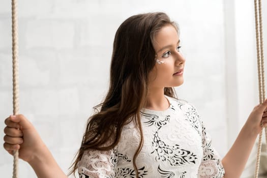 Tennaged pretty girl with fantasy silver makeup and curle long hair wearing nice dress romantic sunny portrait