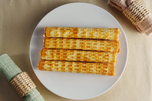 Crispy homemade waffles served on a round platter set against a neutral table setting in soft afternoon light