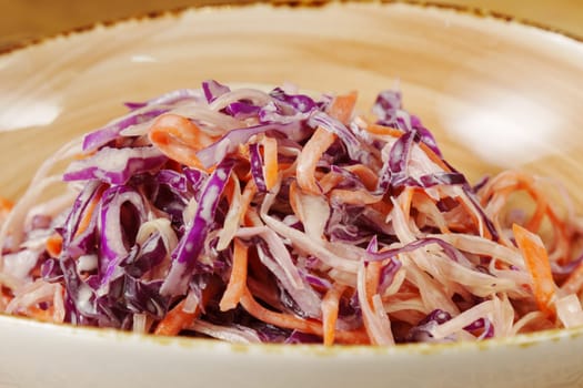 Freshly prepared coleslaw with vibrant purple and orange cabbage served in a rustic bowl, perfect for summer gatherings and picnics