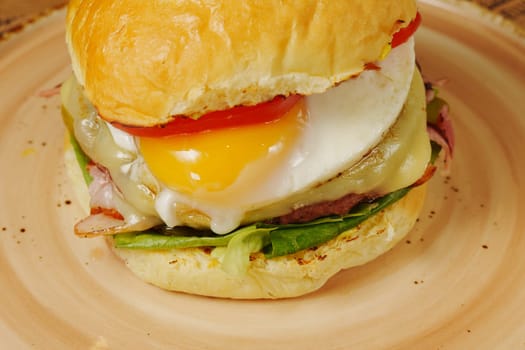 delicious breakfast burger topped with an egg, fresh vegetables, and melted cheese on a warm bun ready