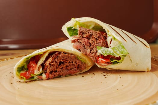 Enjoy a mouthwatering wrap bursting with tender beef, crisp lettuce, and vibrant tomatoes, all wrapped in soft bread