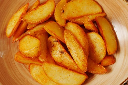 Crispy seasoned potato wedges served in a rustic bowl, a delightful snack perfect for sharing during a cozy gathering