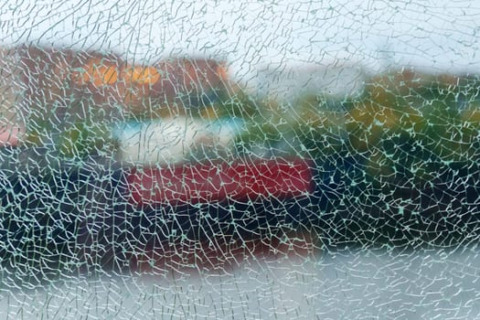 A shattered glass texture beautifully blurs the vibrant colors of the garden beyond, capturing a moment of fractured reflection