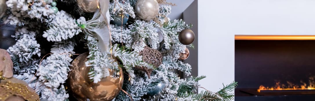 Christmas tree decorated with lovely ornaments and classical style fireplace in white room. New year scene.
