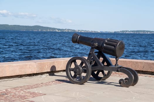 The cannon stands prominently on the shores of Lake Onega, overlooking the water and highlighting local historical significance.
