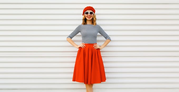 Beautiful happy smiling young woman, pretty girl in red skirt, french beret, heart shaped glasses posing on white background