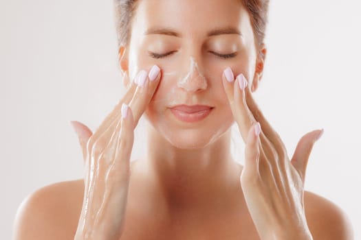 woman washing her face with special skin care product in the morning close-up, facial skin cleansing, skin problems