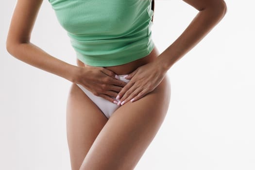 Young woman experiencing discomfort and malaise due to severe abdominal pain, Woman dressed in white underwear on white isolated background experiencing pain due to kidney disease, menstruation