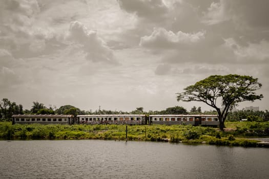 Bangkok, Thailand - May 28,2022 - View of vintage railroad container is parked in wasteland and swamp with sky background. The empty old rusty passenger train and abandoned, Space for text, Selective focus.