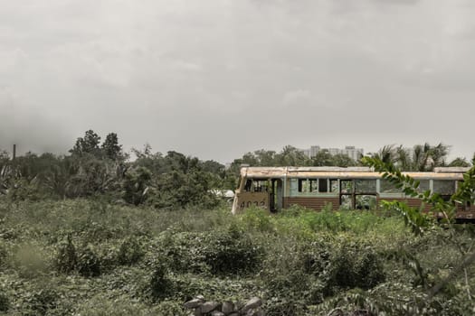 Bangkok, Thailand - May 28,2022 - View of vintage railroad container is parked in wasteland with sky background. The empty old rusty passenger train and abandoned, Copy space, Selective focus.
