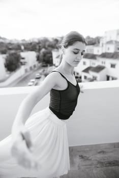 A stunning black and white photo shows a dancer gracefully balancing on a rooftop, showcasing artistry and poise