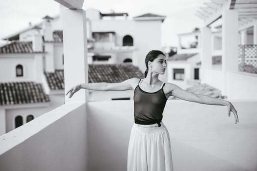 A poised dancer elegantly poses on a balcony, showcasing artistry and movement against a stunning backdrop.
