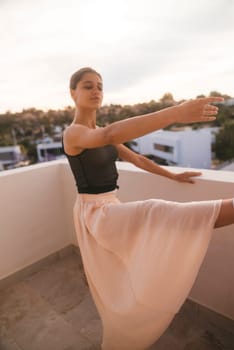 A dancer strikes a dramatic pose on a balcony at sunset, showcasing elegance and captivating beauty