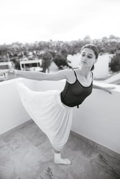 A talented dancer elegantly poses on a charming balcony, blending her captivating grace with the vibrant urban scenery