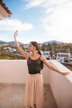 A talented dancer gracefully strikes a captivating pose on a picturesque balcony overlooking stunning mountain views