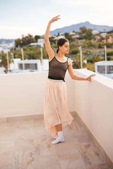 A talented dancer poses gracefully on a balcony that features stunning views, showcasing both elegance and poise