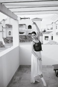 A graceful ballerina beautifully showcases her incredible talent and elegance in a stunning rooftop setting