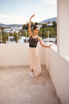 A skilled dancer showcases her artistry while performing on a balcony with a stunning landscape view