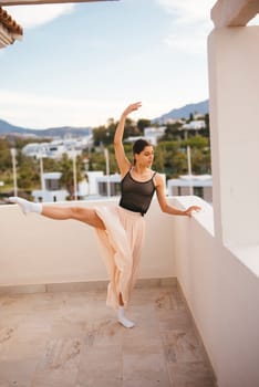 A ballet dancer gracefully poses on a stunning balcony that offers breathtaking views of the majestic mountains