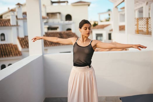 A poised dancer is elegantly performing on a beautiful balcony, showcasing remarkable poise and graceful movement