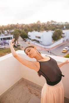 A dancer showcases elegance and freedom on a balcony at sunset, embodying beauty and fluid movement in every pose