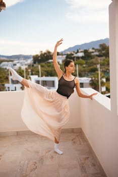 A graceful ballerina magnificently showcases her incredible talent on a beautiful outdoor balcony setting