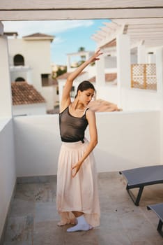 A graceful dancer elegantly showcases her impressive motion and artistry on a serene and picturesque balcony
