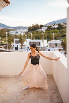 A graceful dancer elegantly showcases her artistry on a beautiful balcony with stunning picturesque scenery