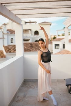 A graceful ballerina beautifully strikes an elegant pose on a stunning rooftop, showcasing both elegance and poise