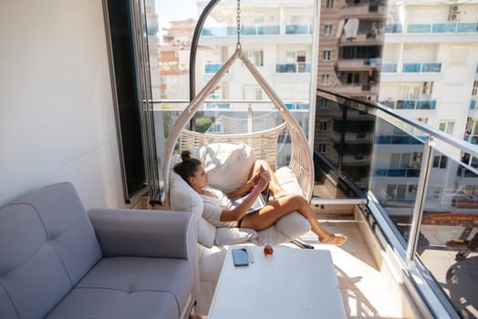 Indulge in pure serenity while relaxing on a cozy balcony featuring a hanging chair and captivating scenic views