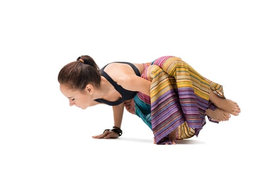 Slim girl striped sarong wraped over her body doing yoga indoors isolated on shot white background