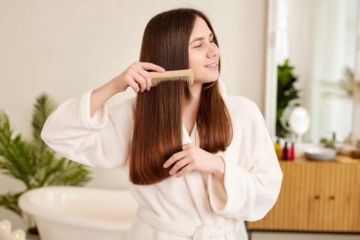 a young girl in a white coat takes care of her hair at home, Hair care concept