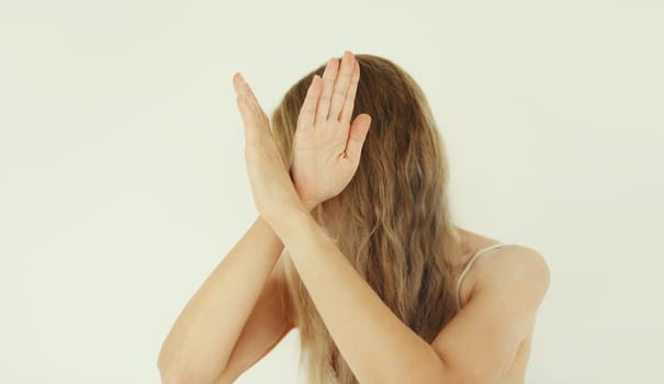 Upset woman shows stop, no or enough sign with palm of hand, refusal gesture, domestic violence.