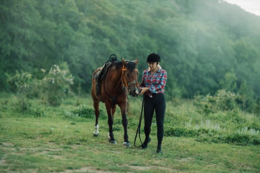 Happy blonde with horse in forest. Woman and a horse walking through the field during the day. Dressed in a plaid shirt and black leggings