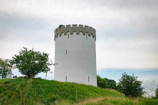 Old white water tower on rampart in city Fredericia, Denmark with blue sky and clouds as background