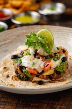 Fish ceviche toast on porcelain plate on wooden table. Spanish name tostada ceviche de pescado