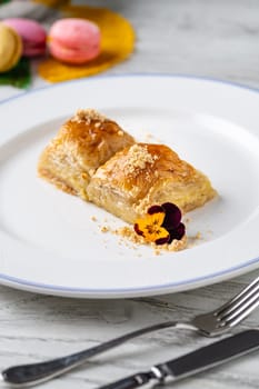 Traditional Turkish dessert walnut baklava on a white porcelain plate