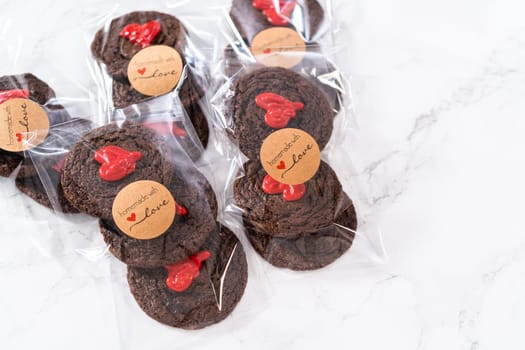 Chocolate cookies with chocolate hearts for Valentine's Day packaged in plastic gift bags.