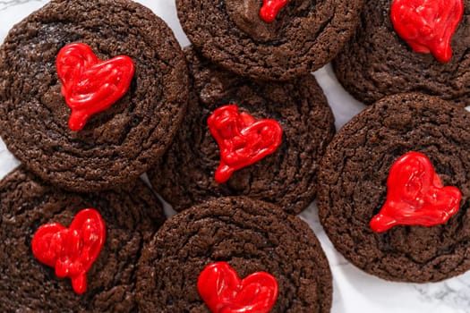 Freshly baked chocolate cookies with chocolate hearts for Valentine's Day.