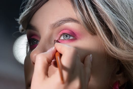 pink eye shadow, girl getting makeup done , close-up