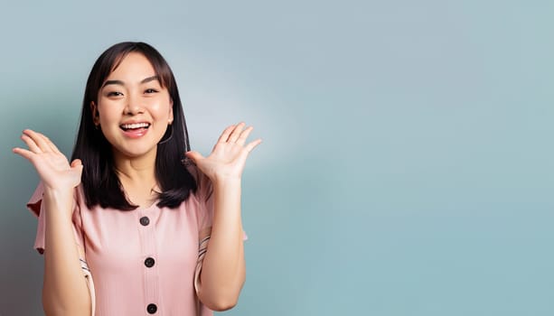 Portrait of young beautiful Asian lady smiling with cheerful expression, shows something amazing at blank space banner background poster wallpaper. AI Generative.