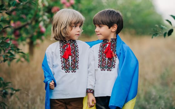Handsome happy boys, ukrainian patriots 4 years old children with national flag on nature backdrop. Ukraine, peace, independence, freedom, future generation.