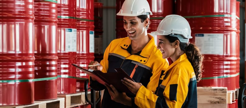 Two factory workers or inventory inspector conduct professional inspection on hazardous chemical barrels in warehouse, chemistry storage workplace and industrial profession concept. Exemplifying