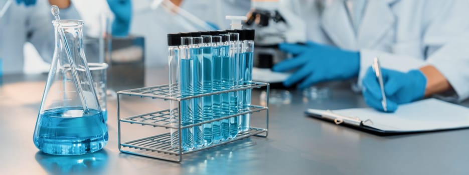 Chemical experiment test tube or medical equipment in laboratory on blurred background of scientist researching vaccine drug or antibiotic. Pharmaceutical and biochemistry lab. Neoteric