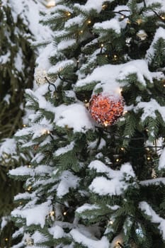 Christmas trees decorated with red balloons in front of the cafe entrance. Street New Year decorations.